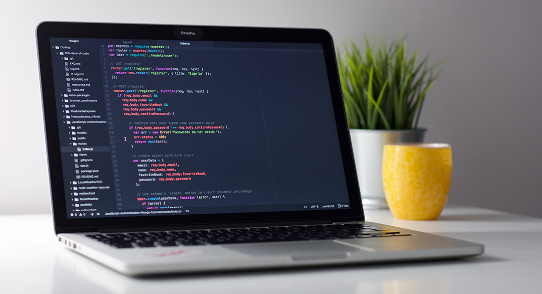 laptop on desk showing code on screen by Clément Hélardot on Unsplash.